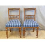A pair of late 19thC/early 20thC dining chairs with carved and bobbin turned decoration