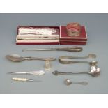 A hallmarked silver spoon, silver sugar tongs, silver ladle,