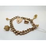 A 9ct gold charm bracelet with 9ct gold charms including tankard, dice,