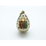 A silver Russian egg pendant with enamel geometric borders,