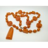 An amber necklace of 40 butterscotch coloured beads of varying shapes, largest approximately 22x9mm,