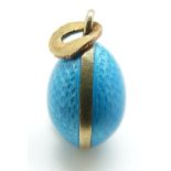 A silver Russian enamel egg pendant set with aqua coloured guilloché enamel, possibly marked 9ct,