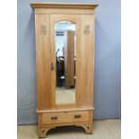 A satinwood Art Nouveau wardrobe with bevelled mirror door and single drawer below,