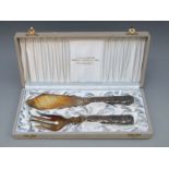 A cased pair of Swedish white metal fish servers with 813H Swedish silver marks for 1907,