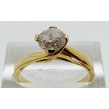 A yellow metal ring set with a modern round brilliant cut diamond of approximately 0.