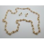 A single strand of cultured pearls with alternating large and small pearls and 9ct gold clasp,