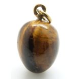 A Russian tiger's eye egg pendant with gold loop marked 9ct, L13.