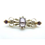 An Edwardian brooch set with an oval cut amethyst surrounded by seed pearls with further round cut