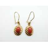 A pair of 18ct gold earrings set with a coral cabochon to each, 3.