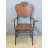 A carved oak armchair with solid seat and back