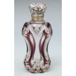 An overlaid cut glass scent bottle with white metal embossed top,