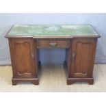 A twin pedestal leather inset break front desk,