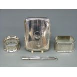 A hallmarked silver cigarette case, two silver napkin rings and a hallmarked silver pencil holder ,