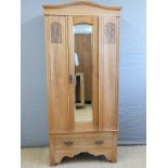 A satinwood Art Nouveau wardrobe with bevelled mirror door and single drawer below,