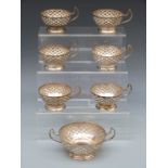 A set of six white metal cup holders and matching sugar bowl holder, believed to be Middle Eastern,