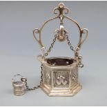 A white metal novelty hexagonal wishing well with chain, pulley and bucket, marked Medusa-Ora,