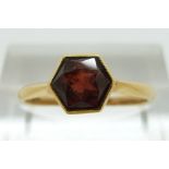 A 22ct gold ring set with a hexagonal cut garnet, size L/M, 2.