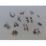 A quantity of silver earrings, some depicting flowers, one pair a gardening trowel and fork,