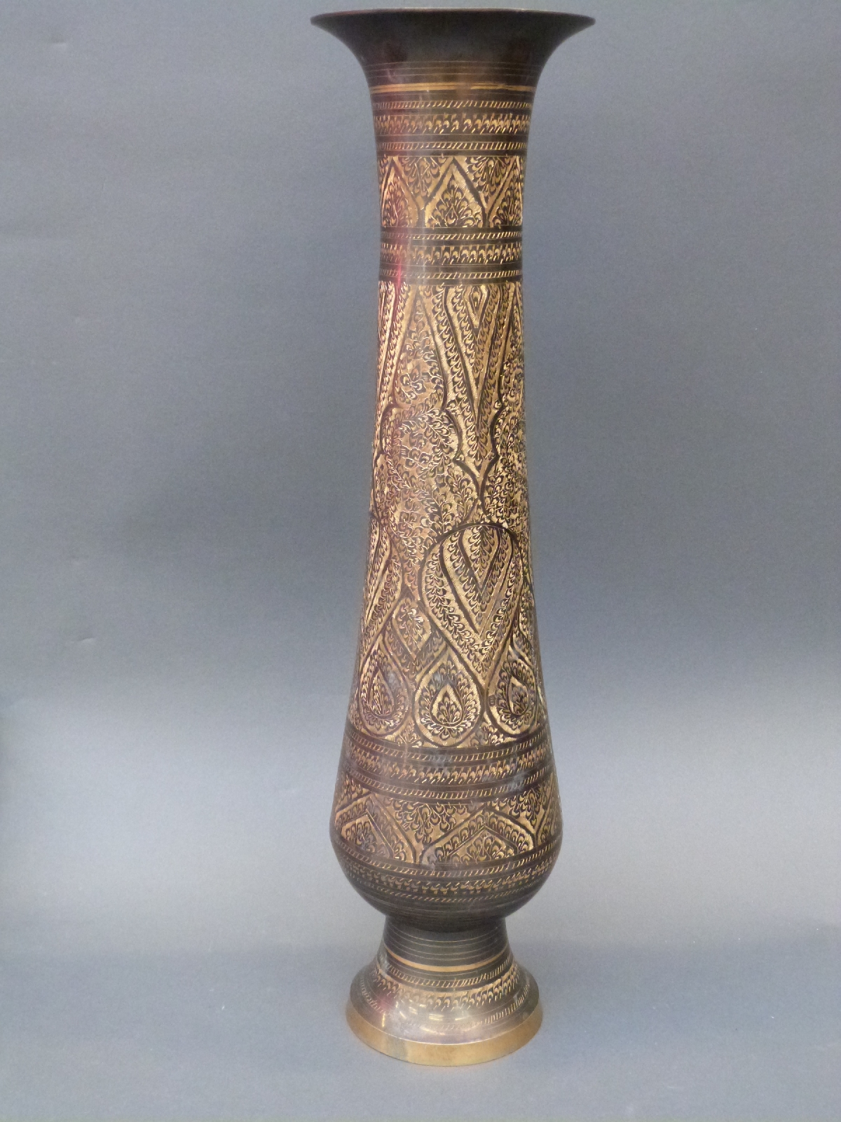 An engraved Persian tall metal vase,