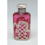 A Victorian cranberry glass scent bottle with silver top and pierced silver decoration,