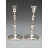 A pair of Georgian hallmarked silver candlesticks of baluster form with engraved crest to both base