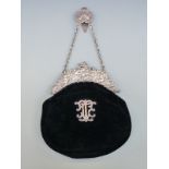 An Edward VII hallmarked silver mounted velvet evening bag decorated with cherubs and with applied