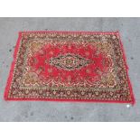 A red ground Persian wool rug with central motif,