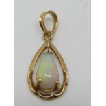 A 14k gold pendant set with a pear cut opal cabochon