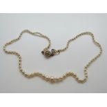 A single strand of 28 cultured and 76 natural pearls,