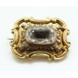 A Victorian brooch set with an aquamarine in a foiled setting within thistle border,