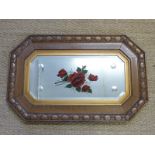 An Edwardian oak framed bevelled glass mirror with hand painted rose decoration,