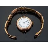 A 9ct gold ladies wristwatch with black hands and Roman numerals, gilt dot minute markers,