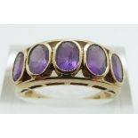 A 9ct gold ring set with five oval cut amethysts, size N, 3.