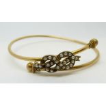 A late Victorian bangle set with seed pearls with sphere ends, marked 9ct,