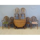 An oak drop leaf table and six (4+2) wheel back chairs, width of table 90cm,