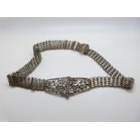 A white metal Indian belt with stylised foliate buckle