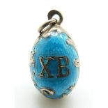 A Russian silver egg pendant set with aqua enamel, 'XB' to one side and a seed pearl to the other,