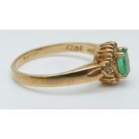 A 9ct gold ring set with an oval emerald surrounded by diamonds, size O, 2.