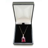 A 9ct gold pendant set with an emerald cut synthetic ruby and diamonds