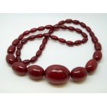 A cherry amber necklace of 47 graduated ovoid beads, the largest approximately 32x24mm, 62g,