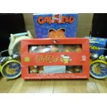 A boxed Garfield ceramic cookie jar together with Garfield alarm clocks, giant watch,