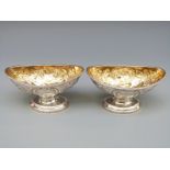 A pair of Georgian hallmarked silver open pedestal salts with embossed decoration and gilt