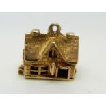A 9ct gold charm / pendant in the form of a pub 'The Horseshoe Inn',