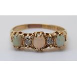 An 18ct gold ring set with three opal cabochons and two old cut diamonds, size S, 3.