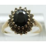 A 9ct gold ring set with a sapphire surrounded by paste, size R/S, 3.