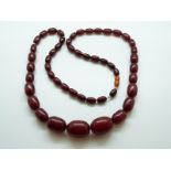 A cherry amber necklace of graduated beads, the largest approximately 2.5cm x 1.