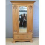 A satinwood Art Nouveau wardrobe with bevelled mirror door and single drawer below,