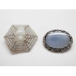 An Arts & Crafts silver mounted chalcedony brooch and Art Deco hexagonal glass spider brooch