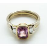 A bi-coloured 18ct gold ring set with an emerald cut pink sapphire and two baguette cut diamonds,