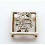 A Victorian buckle set with white enamel border and an inset diamond D in Asprey box